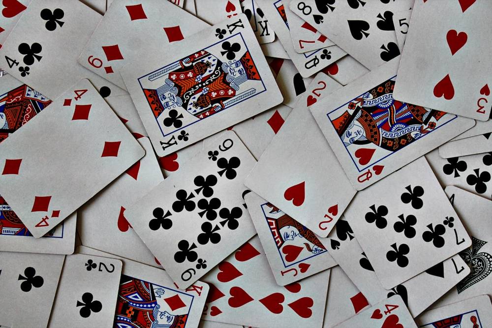 Kartu remi tersusun di atas meja kasino dengan chip berjajar