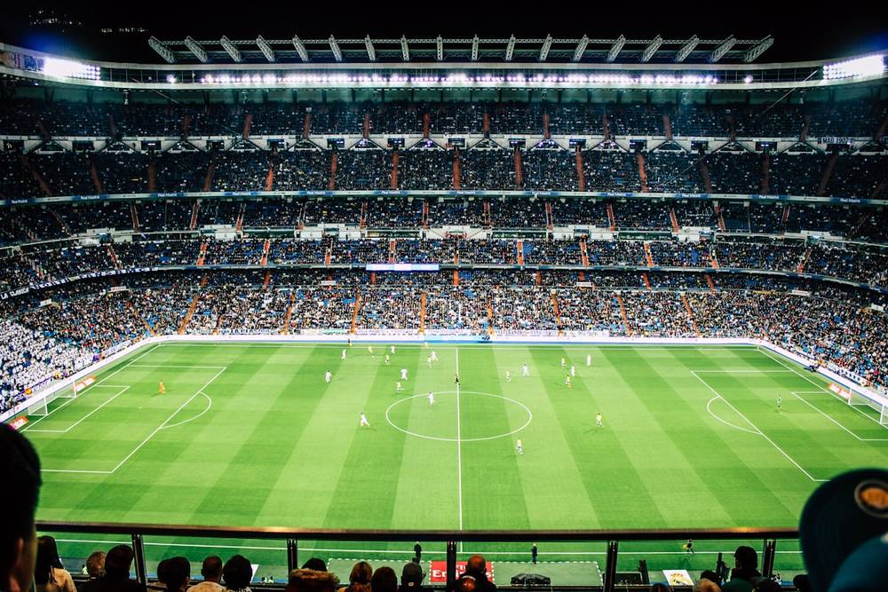Lapangan sepak bola dengan lampu sorot stadion menyala terang